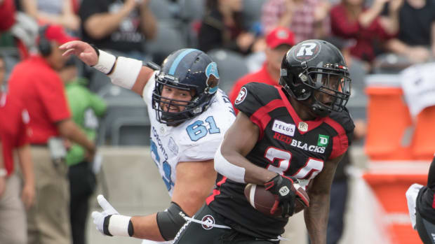 Sep 7, 2019; Ottawa, Ontario, CAN; Ottawa Redblacks defensive back De'Chavon Hayes (34) runs the ball past Toronto Argonauts defensive lineman Sean McEwen (61) in the first half of game at TD Place Stadium. Mandatory Credit: Marc DesRosiers-USA TODAY Sports  